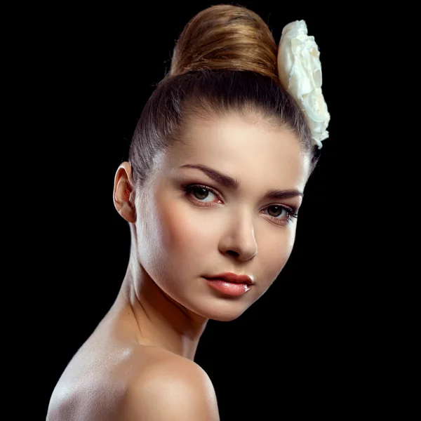 Retrato de una hermosa joven con una flor en el pelo — Foto de Stock