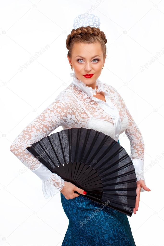 Portrait of a beautiful young woman with fan in hand dancing flamenco.