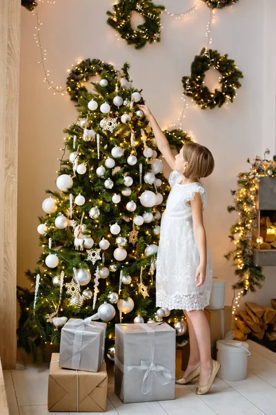 Dziewczyna Białej Sukience Zdobi Choinkę Przed Bożym Narodzeniem Domu Dekoracja — Zdjęcie stockowe