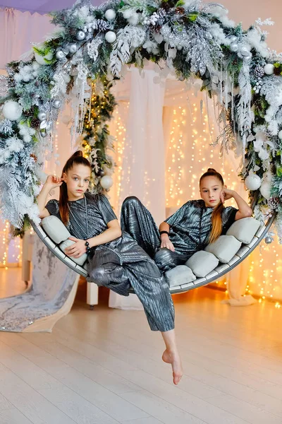 Zwei Teenager Posieren Auf Einer Runden Schaukel Einem Weihnachtlich Dekorierten — Stockfoto