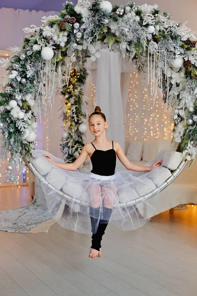 Ein Mädchen Balletttutu Sitzt Auf Einer Runden Schaukel Mit Weihnachtsdekoration — Stockfoto