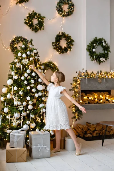 Ein Mädchen Weißen Kleid Schmückt Den Weihnachtsbaum Hause Vor Weihnachten — Stockfoto