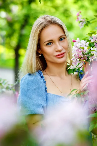정원의 파란색 드레스를 아름다운 소녀와 사쿠라의 벚꽃이 계절에 공원에서 즐기는 — 스톡 사진
