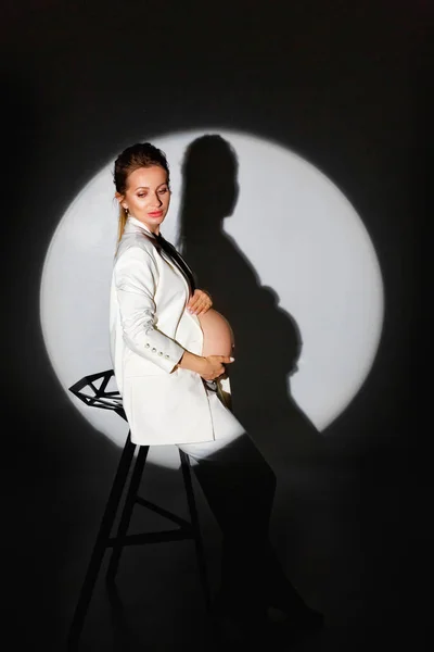 Uma Jovem Mulher Bonita Elegante Terno Branco Fica Estúdio Escuro Imagem De Stock