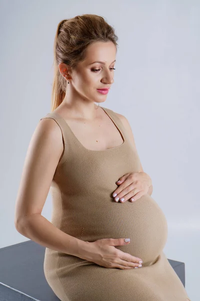 Close Portrait Pregnant Woman Beige Dress Hugging Her Stomach Both — Stock Photo, Image