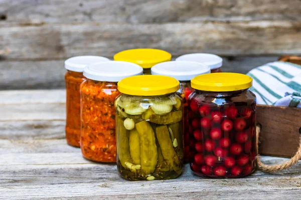 Jars with variety of canned vegetables and fruits, jars with zacusca. Preserved food concept in a rustic composition.