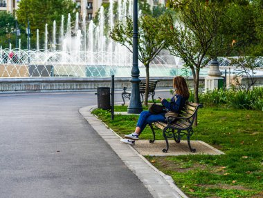 2021 Bükreş, Romanya 'da bir bankta tek başına oturan bir kız