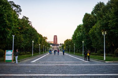 Romanya 'nın Bükreş kentindeki Carol Park' ın ana caddesinde yürüyen insanlar