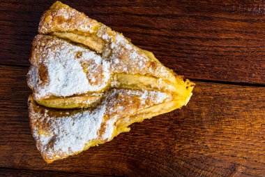 Kırsal ahşap masada tarçınlı dilimlenmiş elmalı turta.