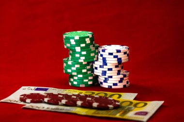 Kırmızı arkaplanda parası olan poker çipleri yığını, EURO para birimi