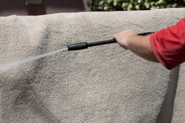 Yüksek basınçlı yıkamalı halılar. Yüksek basınçlı suyu yıkamak için halıyı silahla temizlemek.