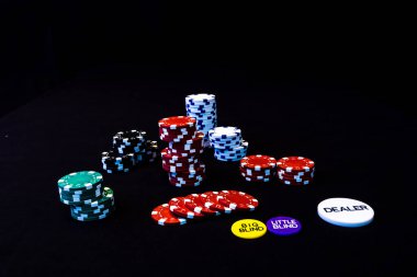 Siyah arkaplanda poker çipleri yığını