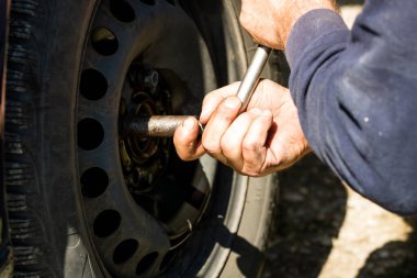 Romanya 'nın Bükreş kentindeki araba garajında araba tamircisi lastik değiştiriyor.