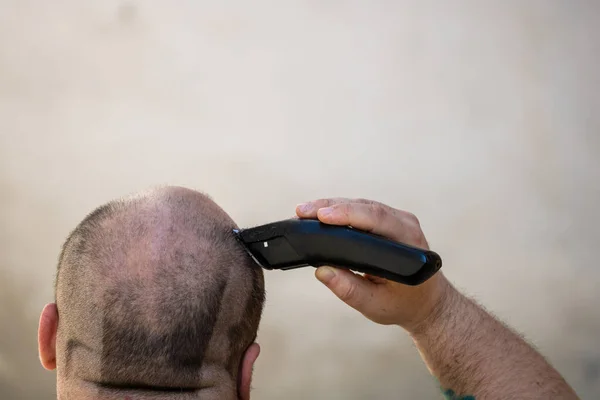 用剃须刀或电动剃须刀刮头或修剪头发的男性 — 图库照片