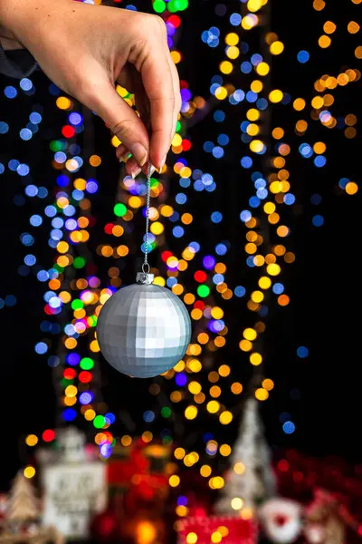 Tenendo Decorazione Natale Contro Bokeh Luci Sfondo — Foto Stock