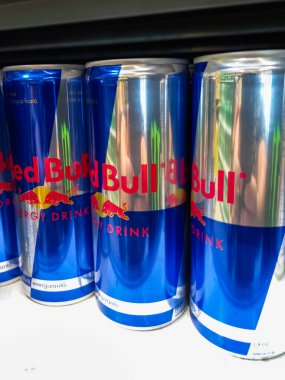 Mavi konserve Red Bull enerji içeceği süpermarkette rafta. Romanya 'nın Bükreş kentinde yayınlanan illüstrasyon fotoğrafı, 2021