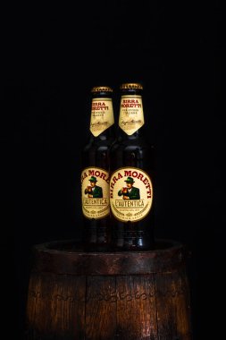 Bir şişe Birra Moretti birası. Ahşap fıçının üzerinde, koyu arkaplanlı. Bükreş, Romanya, 2021