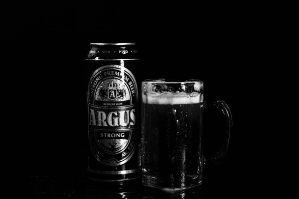 暗い背景にアーガスビールとビールグラスの缶 ルーマニアのブカレストで撮影された写真 2021年 — ストック写真