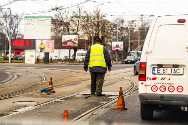 Romanya 'nın Bükreş kentindeki tramvay raylarında trafik konisi düzenleyen işçiler, 2021
