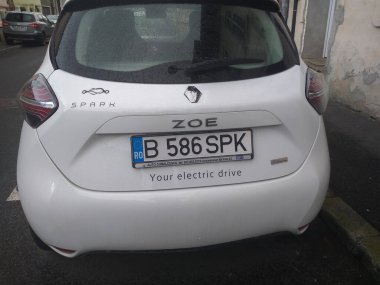 Yeni elektrikli araba, Beyaz Spark Renault Zoe sokakta. Romanya 'nın Bükreş kentinde otomobil paylaşım hizmeti, 2021