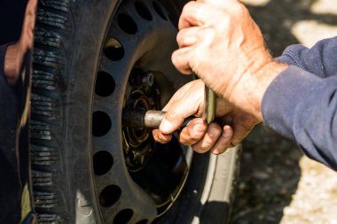 Romanya 'nın Bükreş kentindeki araba garajında araba tamircisi lastik değiştiriyor.