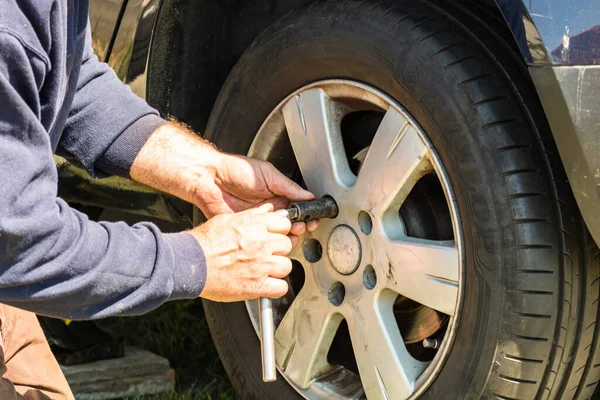 Auto Meccanico Avvitando Svitando Ruota Auto Con Chiave Inglese Garage Foto Stock