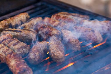 Mangalda mici ya da mititei denilen rulo köfteleri hazırlıyorum. Izgarayı alev ve dumanla yakın..