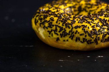 Siyah arka planda serpiştirilmiş taze renkli çörekler.