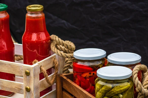 赤ピーマンを漬けガラス瓶と木製のクレートとキュウリ 孤立した 酢漬け野菜の様々な瓶 素朴な構成で保存食の概念 — ストック写真