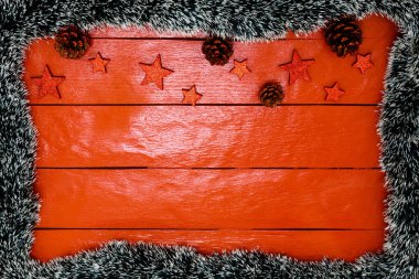 Noel çelengi ve süslemeleri olan kırmızı tahta üzerinde Noel kompozisyonu. Sınır ve kopyalama alanı ile yaratıcı kompozisyon, üst görünüm, düz yatay. Noel çerçevesi.