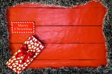 Noel çelengi ve süslemeleri olan kırmızı tahta üzerinde Noel kompozisyonu. Sınır ve kopyalama alanı ile yaratıcı kompozisyon, üst görünüm, düz yatay. Noel çerçevesi.