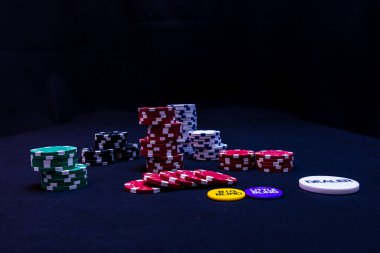 Siyah arkaplanda poker çipleri yığını