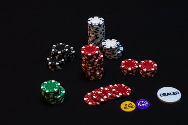 Siyah arka planda poker fişleri yığını, poker fişleri yayılmış, büyük kör, satıcı, poker konsepti.