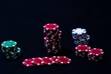 Siyah arkaplanda poker çipleri yığını