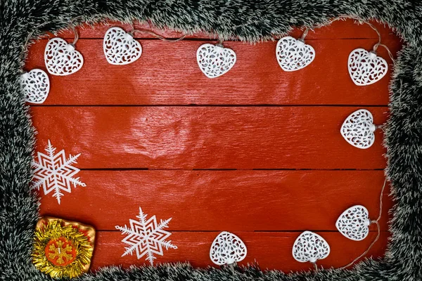 クリスマスのガーランドと装飾と赤い木製のボード上のクリスマスの組成 境界線とコピースペース トップビュー フラットレイアウトと創造的な組成 クリスマス フレーム — ストック写真