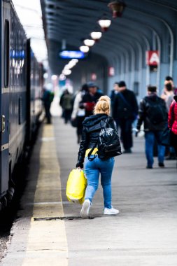Bükreş 'teki Bükreş Kuzey Tren İstasyonu' nun (Gara de Nord Bükreş) tren peronunda tren bekleyen gezginler ve banliyö sakinleri, 2022