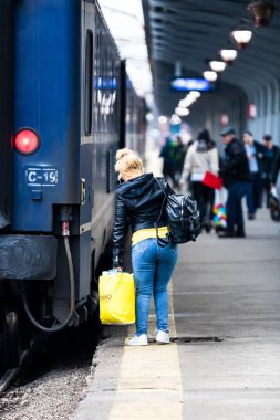 Bükreş 'teki Bükreş Kuzey Tren İstasyonu' nun (Gara de Nord Bükreş) tren peronunda tren bekleyen gezginler ve banliyö sakinleri, 2022