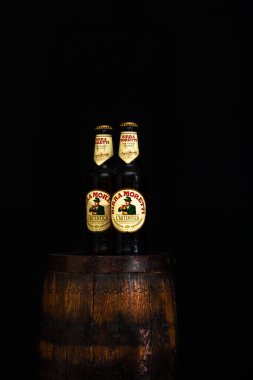 Bir şişe Birra Moretti birası. Ahşap fıçının üzerinde, koyu arkaplanlı. Bükreş, Romanya, 2021
