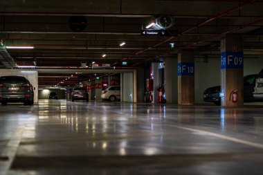 Otoparkın içinde park edilmiş birkaç araba var. Bükreş, Romanya 'daki yeraltı otoparkı, 2021