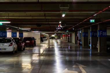 Otoparkın içinde park edilmiş birkaç araba var. Bükreş, Romanya 'daki yeraltı otoparkı, 2021