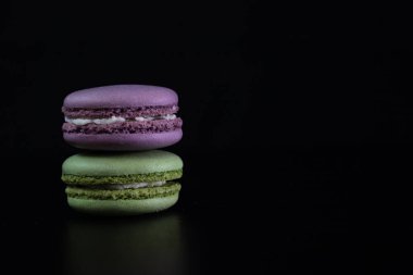 Siyah arka planda izole edilmiş rengarenk badem kurabiyeleri, Fransız badem kurabiyeleri.