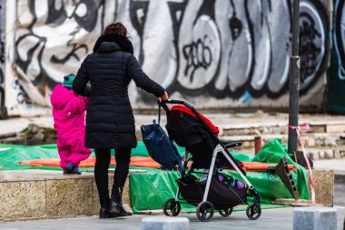 2022 Bükreş, Romanya 'da çocuklu bekar bir anne bebek arabasıyla geziyor.