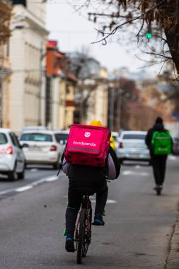 Romanya 'nın Bükreş kentinde bisikletli bir Food Panda kuryesi, 2022