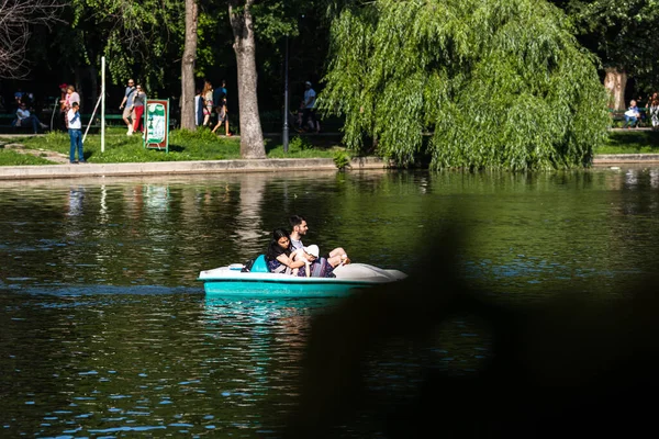 Cismigiu Park, Bükreş, Romanya 'da 2020' de göl kenarındaki pedallı teknedeki insanlar. İnsanlar karantina ve koronavirüs kısıtlamalarından sonra parkta yürüyor, eğleniyor, eğleniyor..