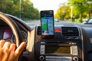 Waze haritalarını gösteren akıllı telefonlu bir araç paneli görünümünde. Sürücü Bükreş, Romanya 'daki Waze haritalarını kullanıyor, 2020