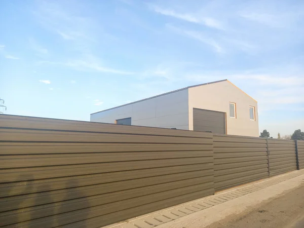 Warehouse building with fence. Industrial warehouse