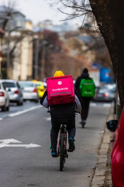 Romanya 'nın Bükreş kentinde bisikletli bir Food Panda kuryesi, 2022