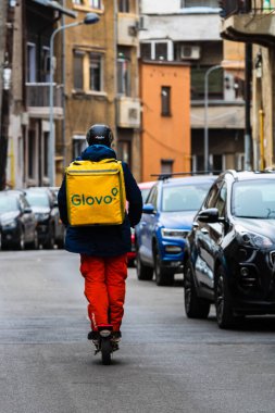 Romanya 'nın Bükreş kentinde bisikletli bir Glovo gıda kuryesi, 2022
