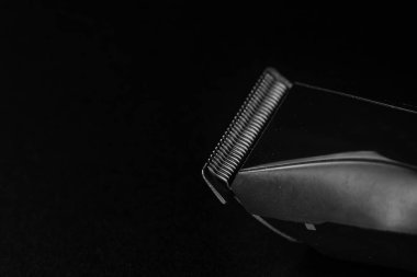 Saç çıkarma konsepti, siyah arka planda izole edilmiş elektrikli jilet..