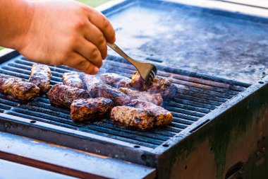 Mangalda mici ya da mititei denilen rulo köfteleri hazırlıyorum. Izgarayı alev ve dumanla yakın..